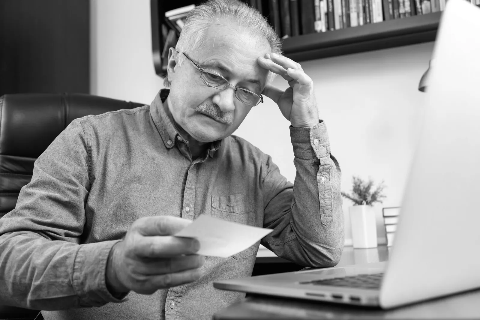 A home services owner at a desk reviewing invoices and lead reports
